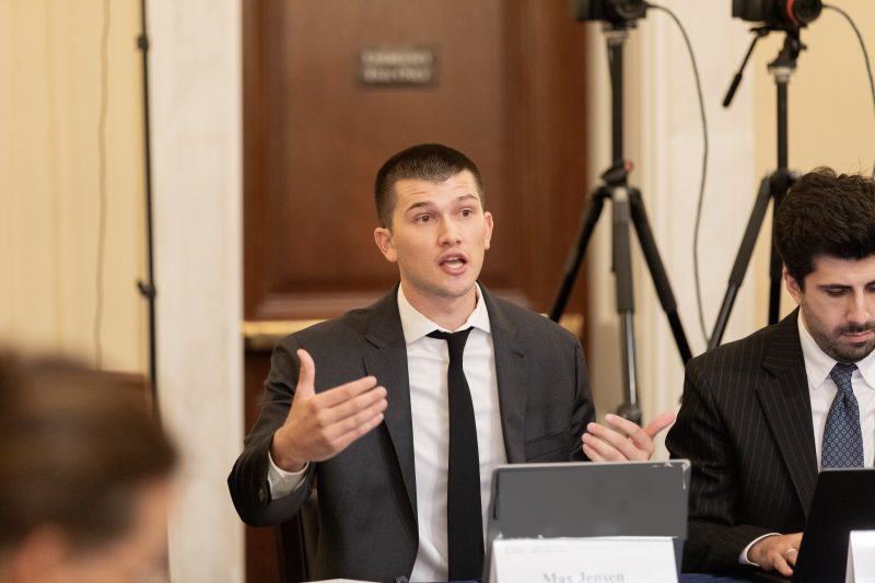 Max Jensen seated at his nameplate in the room at the CSIS event of 21 July 2026.
